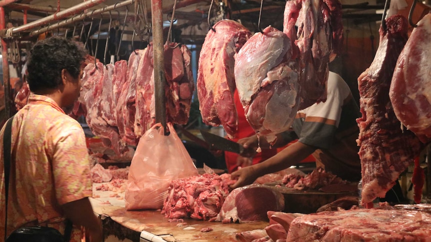 An Indonesian consumer buys beef at a local wet market.