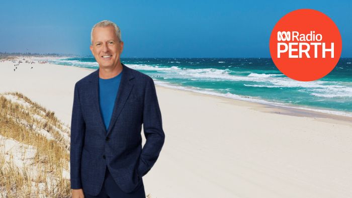 A man standing with a beach in the background