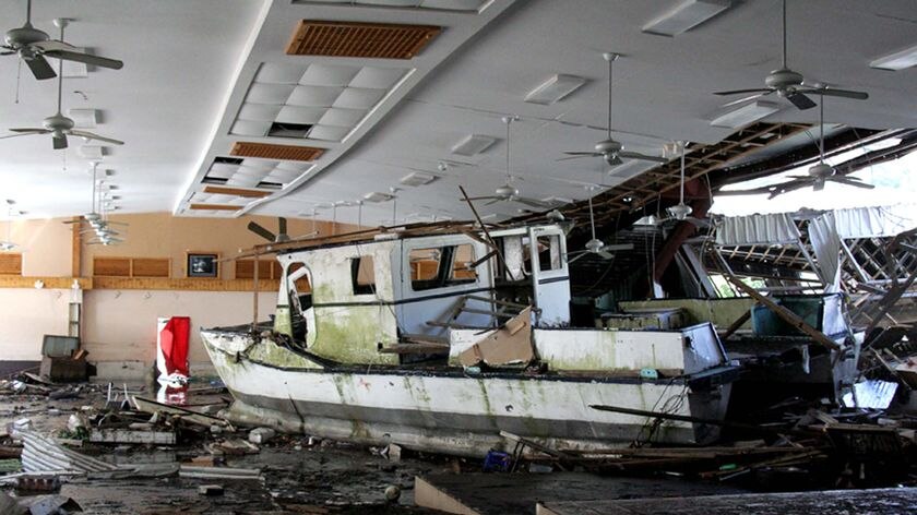 A damaged boat sits inside a building in Pago Pago.