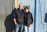 Trevor Memory and his wife Gemma standing in front of the galvanised and rustic timber renovated apple shed at Gardners Bay.