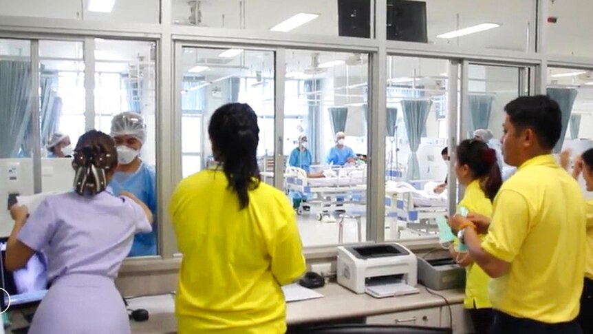 Family members watch boys through a window at Chiang Rai hospital