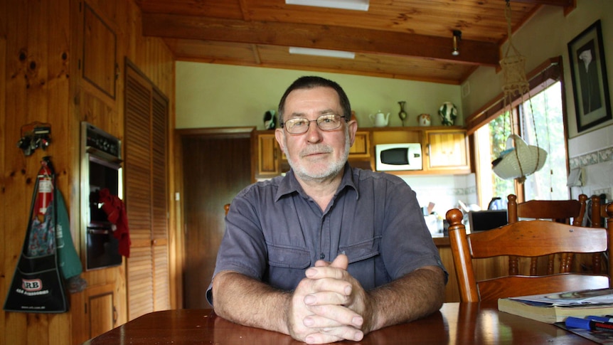 Denis Clough sitting at his kitchen table