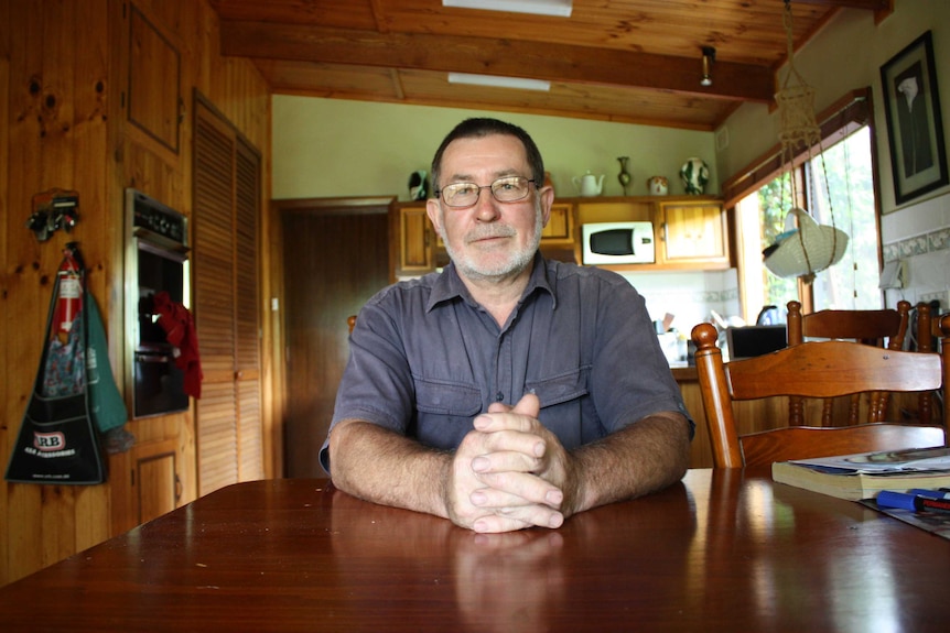 Denis Clough sitting at his kitchen table