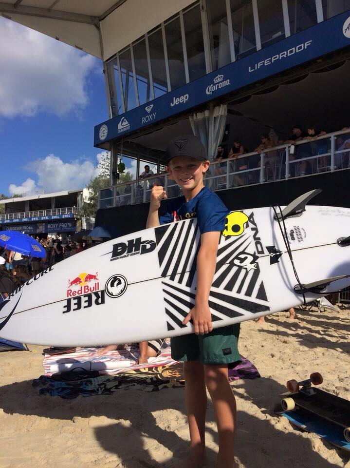 [Nate Johnson poses with his new surfboard gifted by Mick Fanning at Snapper Rocks, Gold Coast]