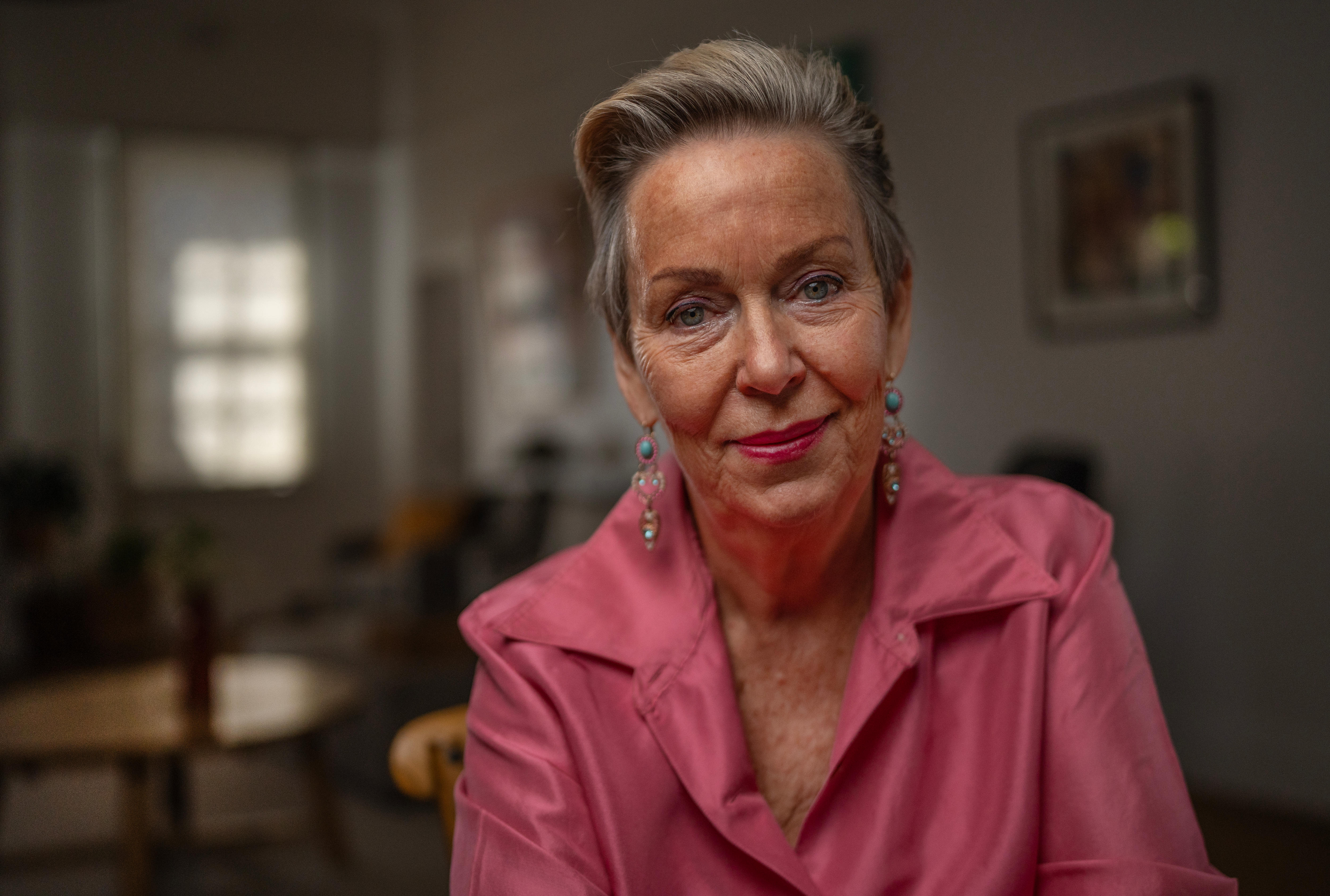 Woman sitting at table, smiling at camera