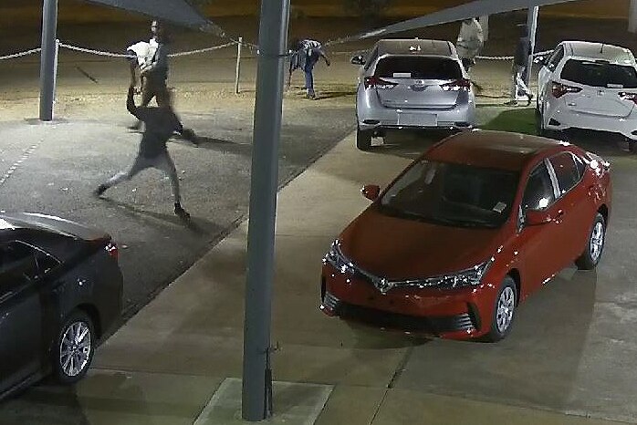 youths throwing rocks at new cars in a sale yard