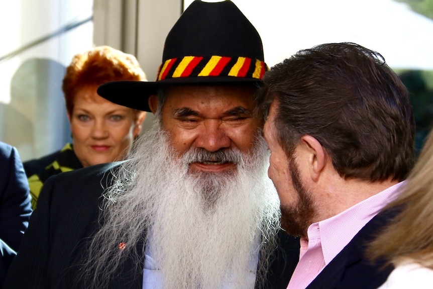 Labor Senator Pat Dodson speaks with Senator Derryn Hinch, with One Nation's Pauline Hanson standing behind them.
