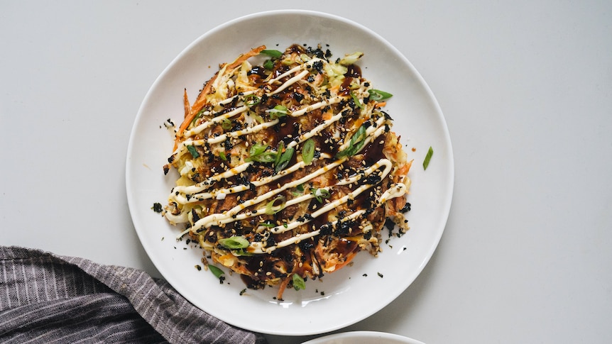 A plate with vegetarian carrot and cabbage okonomiyaki, a comforting recipe.