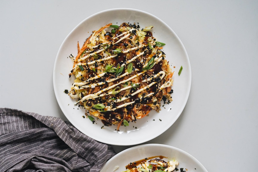 A plate with vegetarian carrot and cabbage okonomiyaki, a comforting recipe.