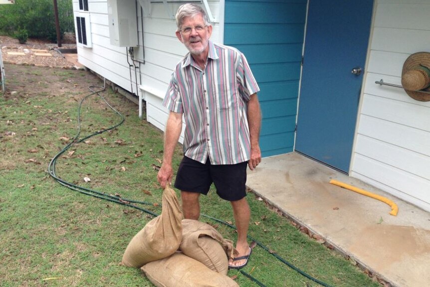Cungulla resident Graham puts sandbags around his house, before leaving to travel to Townsville.