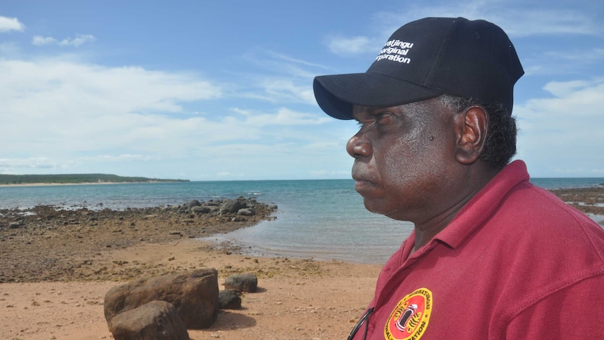Rirratjingu traditional owner Wanyubi Marika is standing on the beach with a serious expression.