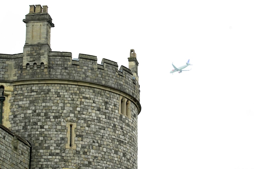 A plane flies over the castle
