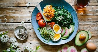 Vegetables, avocado and eggs on a plate.