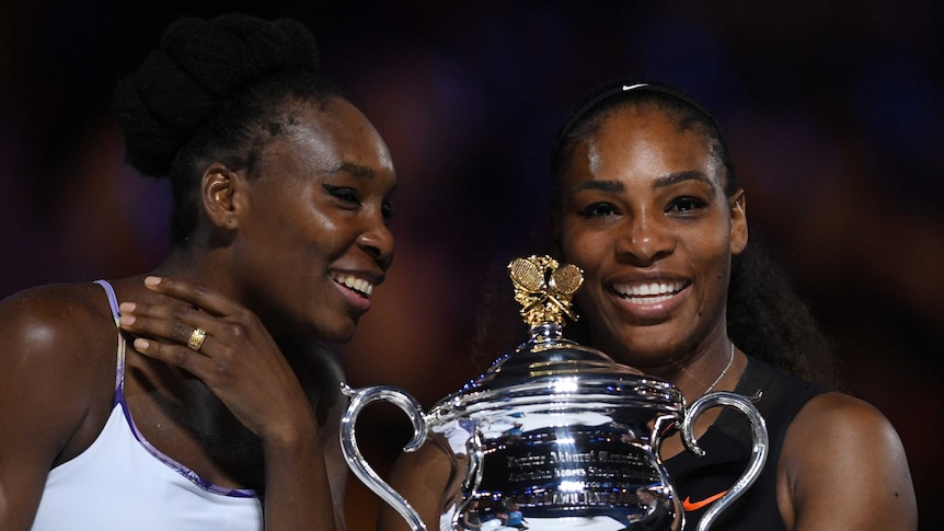 Serena (R) and Venus share a laugh during the Australian Open presentation ceremony.