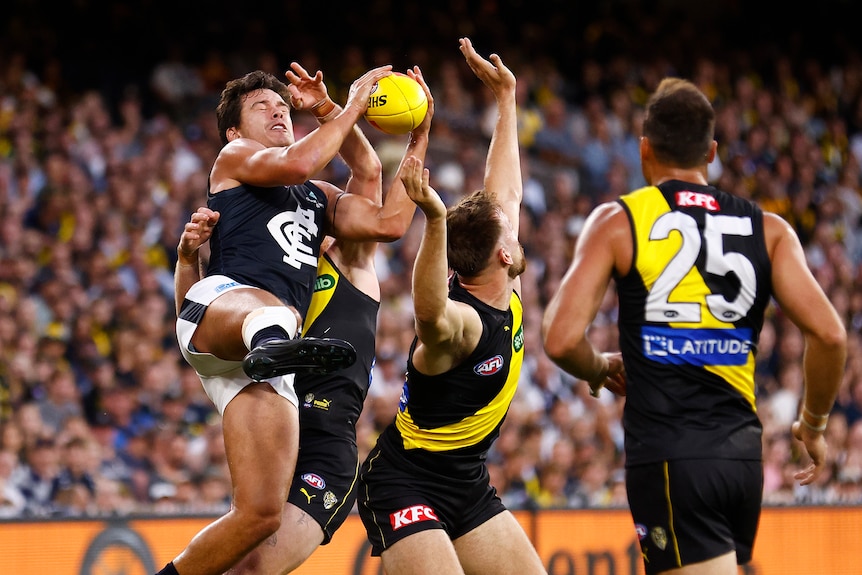 Jack Silvagni takes a mark above a number of Richmond players