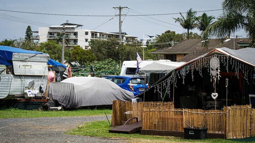 A caravan park with cars and permanent shelters set up inside.