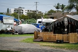 A caravan park with cars and permanent shelters set up inside.