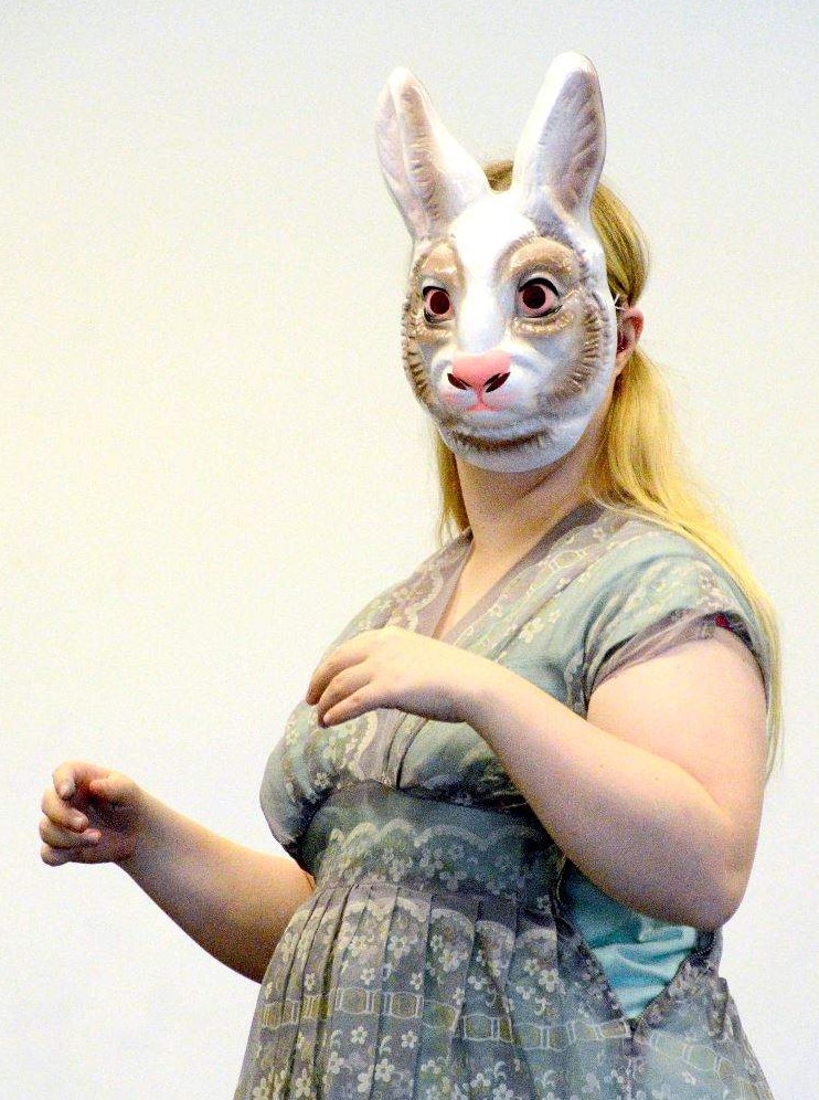 A woman wears a rabbit mask.