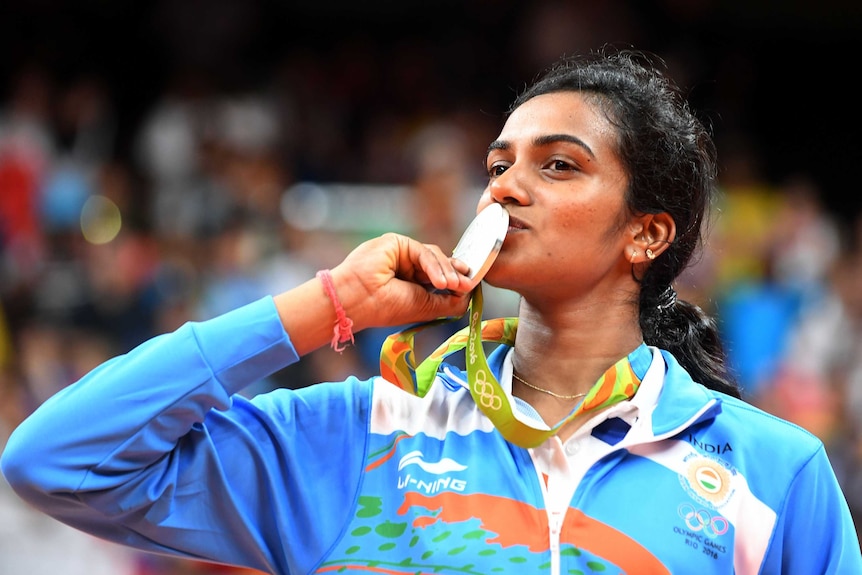 Indian Olympian Pusarla V. Sindhu kisses her silver medal.