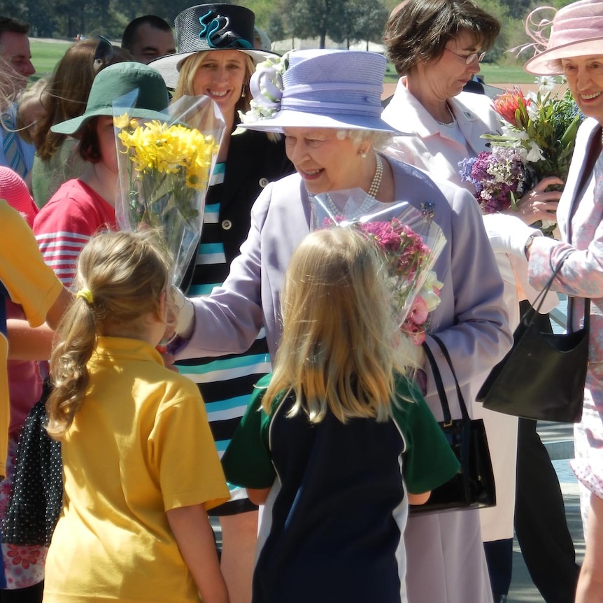 Queen Elizabeth II receives flowers from local children at Floriade in Canberra