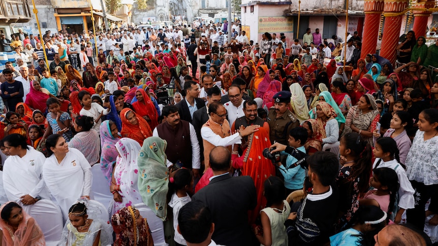 Senior Bharatiya Janata Party (BJP) leader Shivraj Singh Chouhan reacts as women greet him at an event.