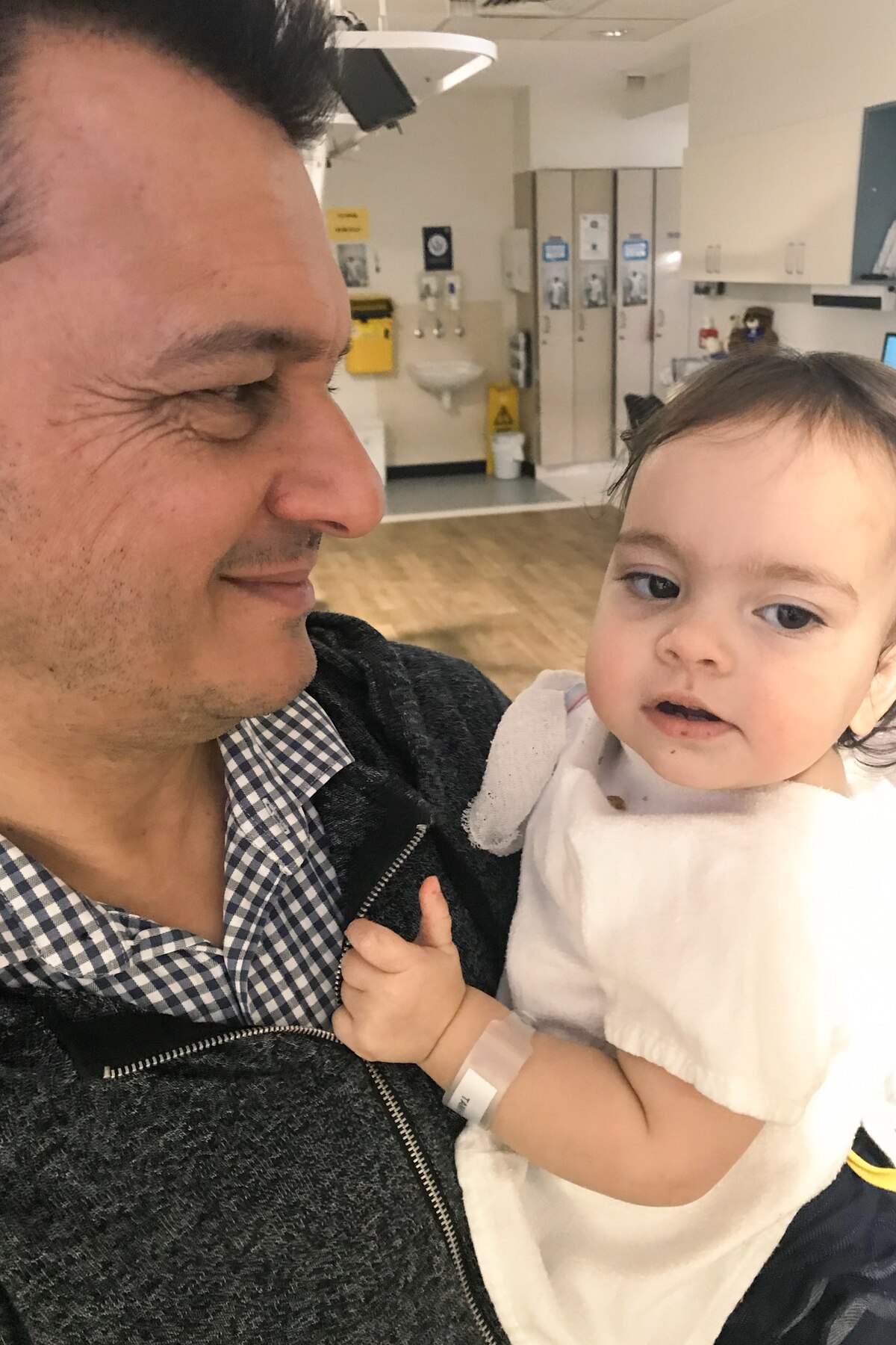 Mark Tamhane holds one of his children.