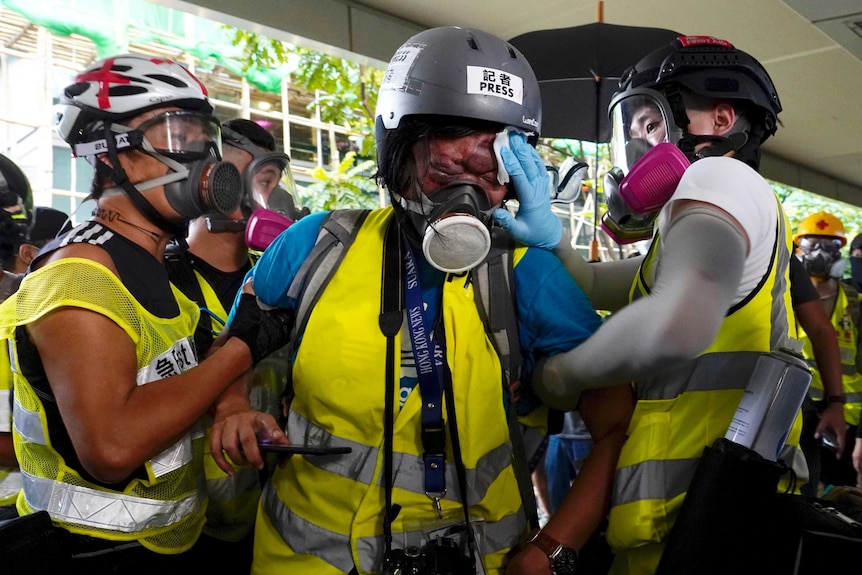 Veby Mega Indah, center, who got injured in police firing is attended to help by others.