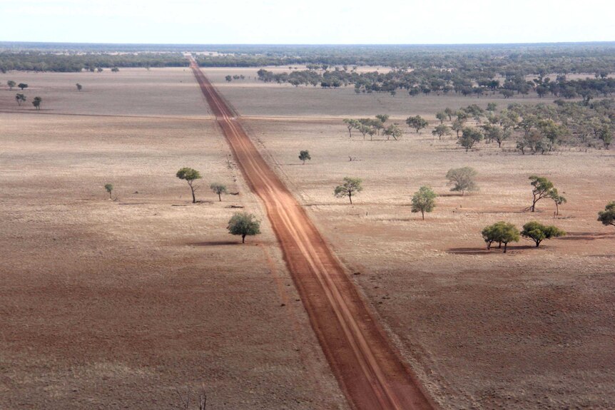 A dirt road crosses a rural property.