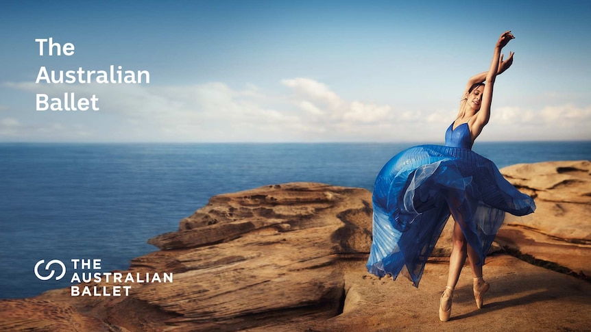 Woman wearing a billowy blue dress is mid-dance on top of a cliff overlooking the ocean