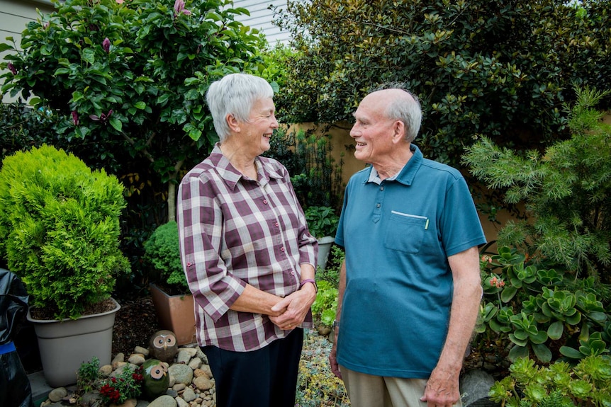 The Goldsmiths smiling at each other in their garden.