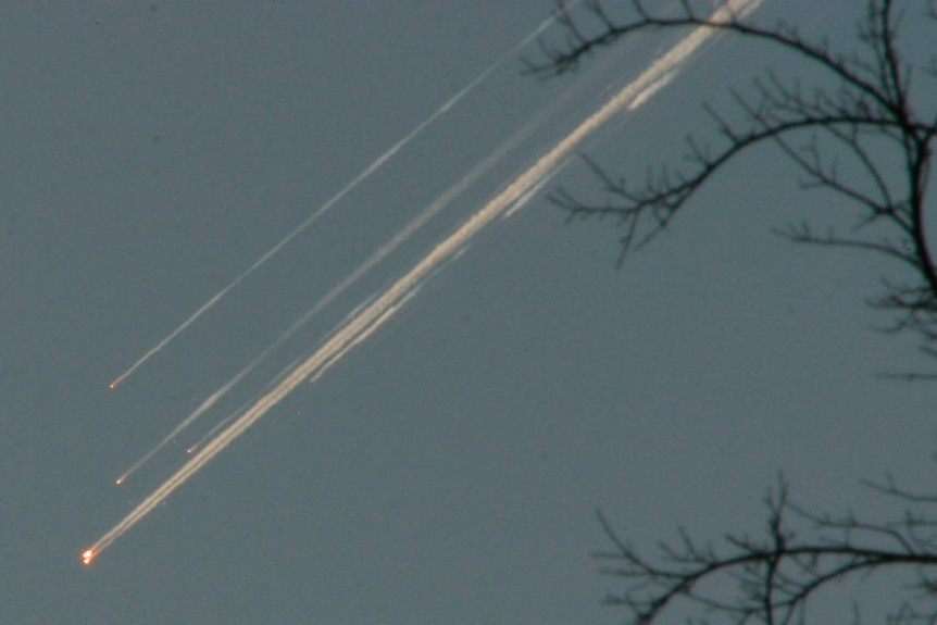 bits of space debris from the space shuttle Columbia streak downwards across the sky 