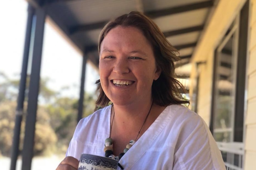 A woman holding a mug on a veranda