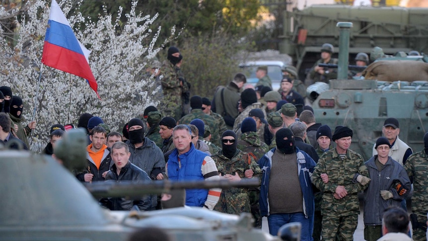 Pro-Russian militiamen cordon off as Russian soldiers storm the Ukrainian military airbase in Belbek