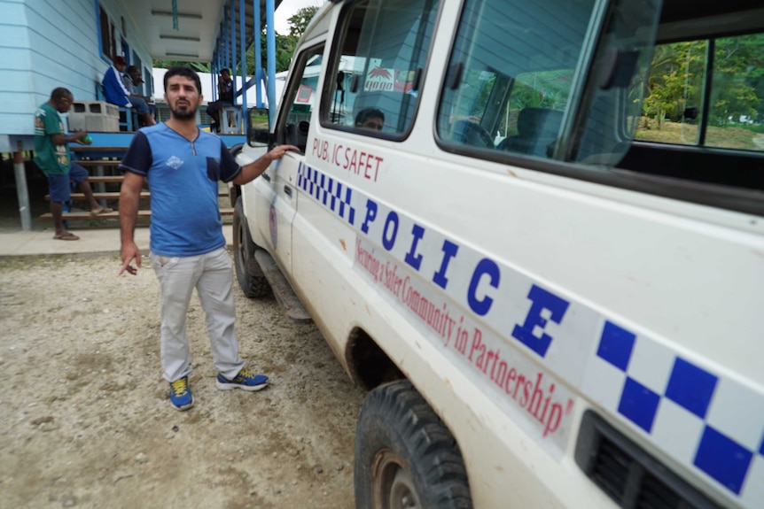 Benham Satah next to a Manus Island police van