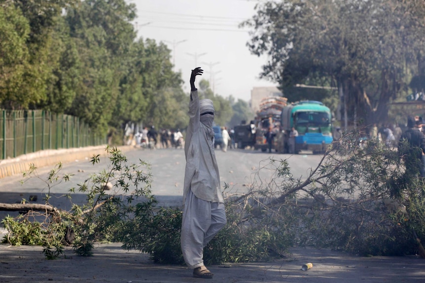 A supporter of the Tehreek-e-Labaik Pakistan gestures after blocking the main road leading to the airport in Karachi.
