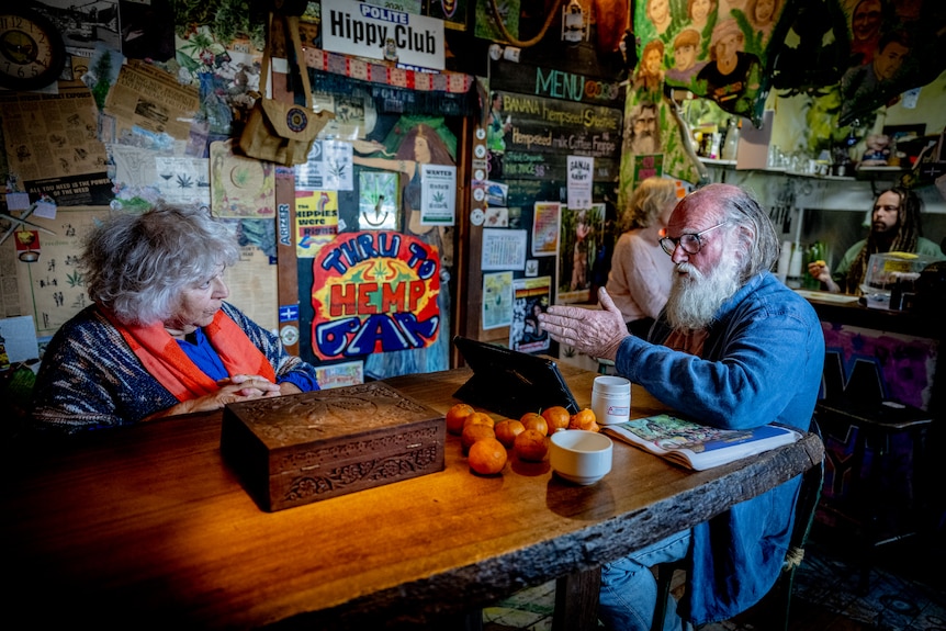 Michael Balderstone and Miriam Margolyes sitting at a table in Nimbin speaking