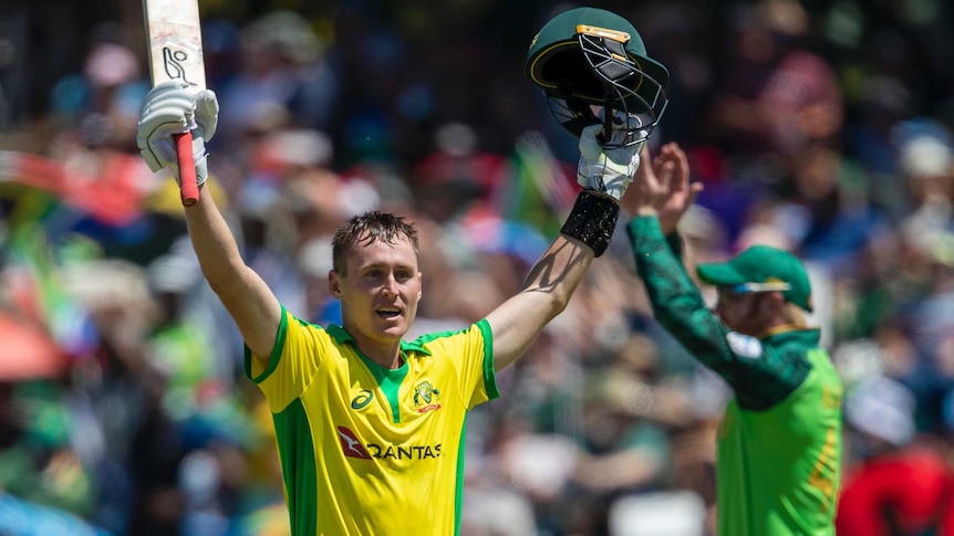 An Australian batsman raises his bat in one hand and his helmet in the other after an ODI century.
