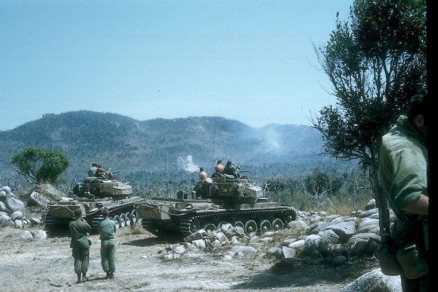 Australian troops in Vietnam practise shooting targets in the hills from centurion tanks