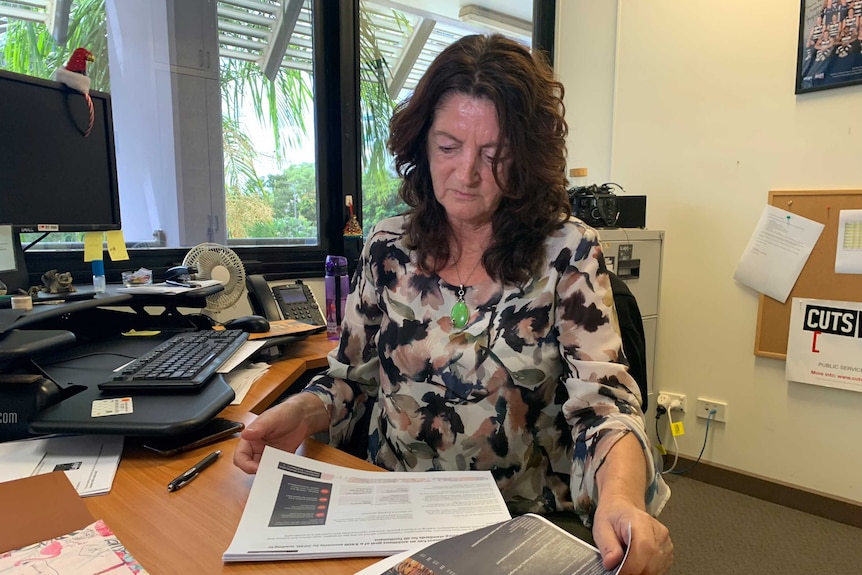 CPSU NT Secretary Kay Densley sits at her busy desk and sifts through paperwork.