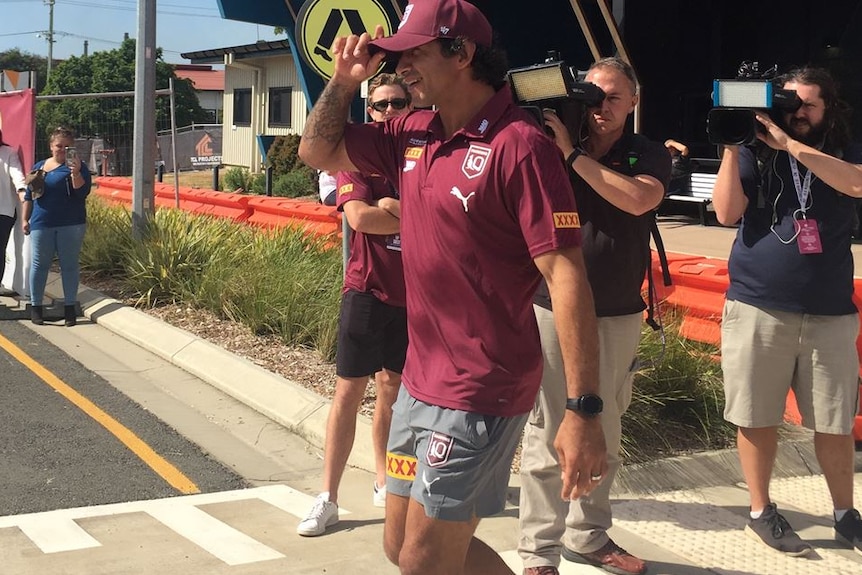 A man walks with cameras following him.