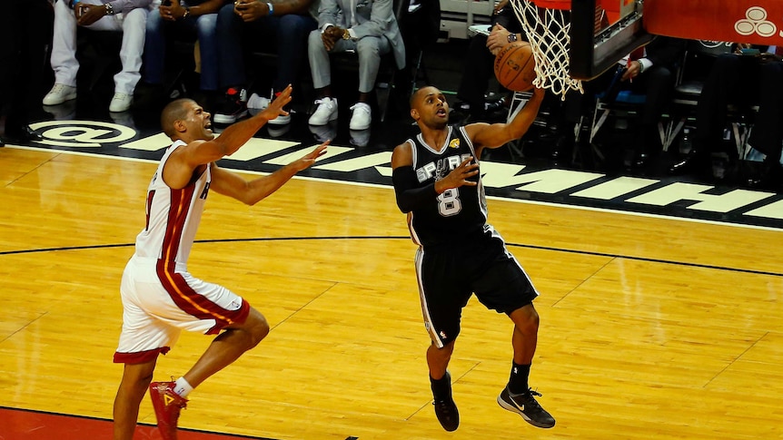 San Antonio's Patty Mills (R) goes to the basket in game four of the NBA Finals against Miami Heat.