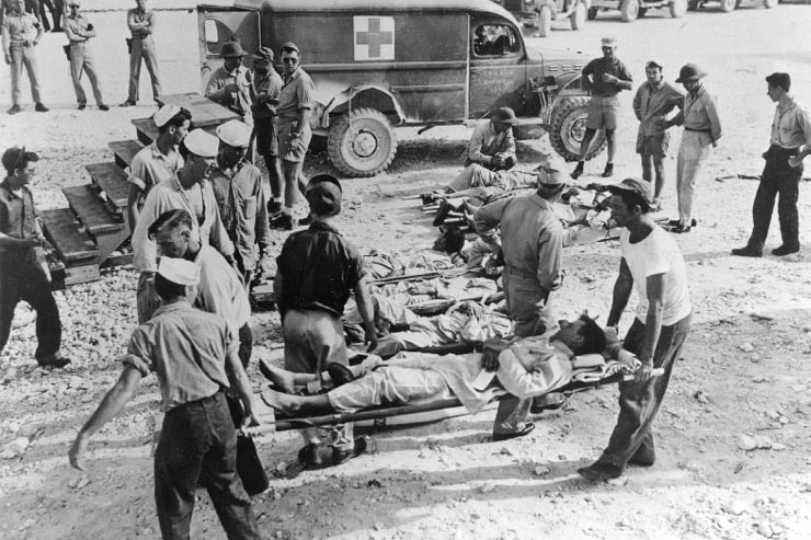 Black and white photo of soldiers on stretchers.
