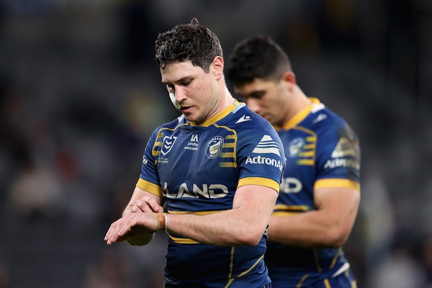 A man removes strapping tape after losing a rugby league match