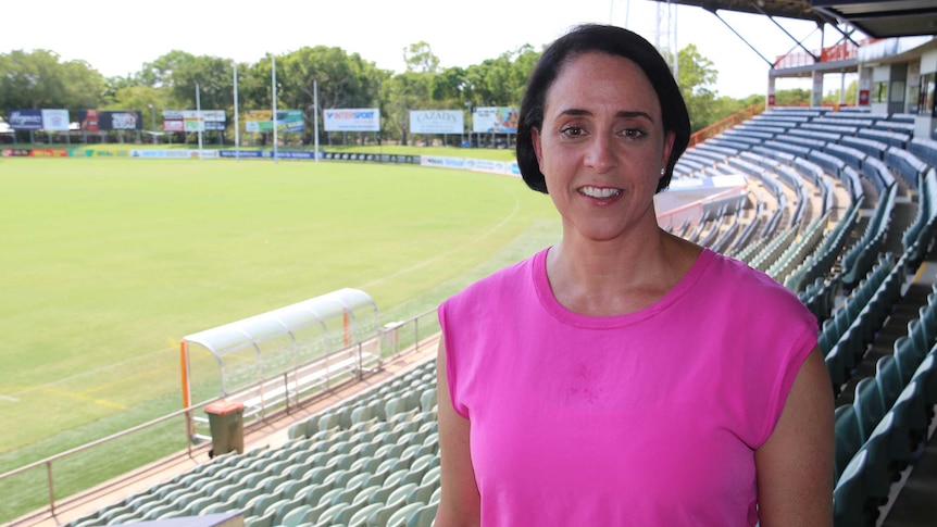 AFL Women's League CEO Nicole Livingstone stands in a football stadium grandstand