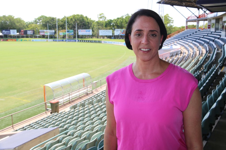 AFL Women's League CEO Nicole Livingstone stands in a football stadium grandstand
