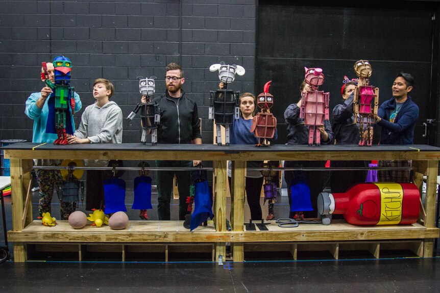 The puppeteers line up the characters as part of rehearsal.