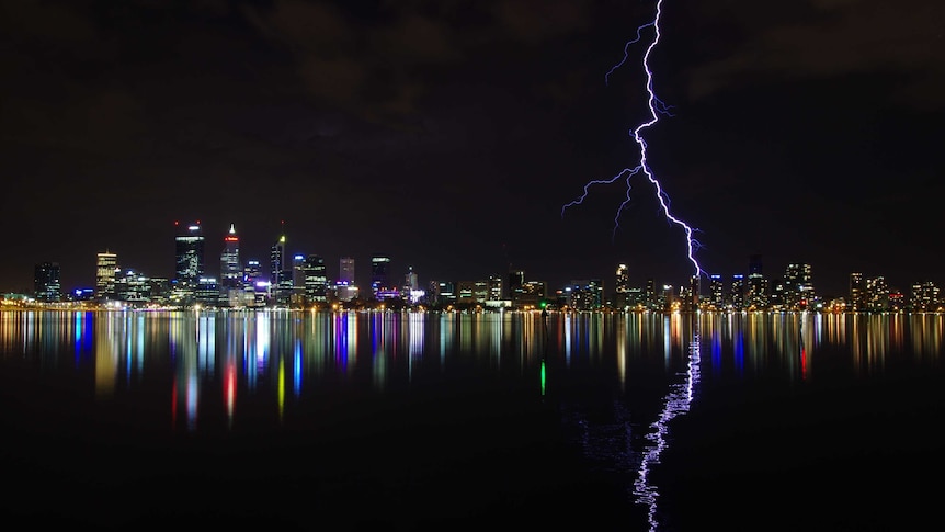 A large bolt of lightning strikes the Perth skyline at night.