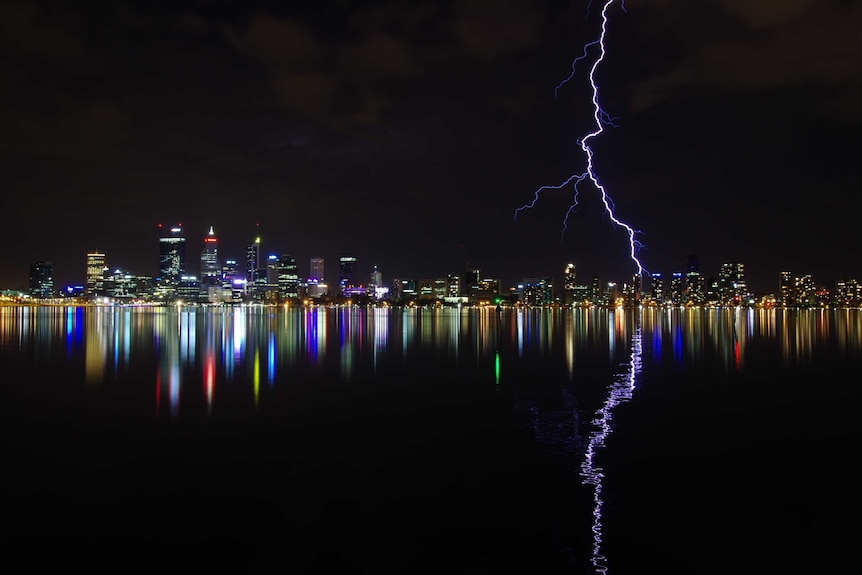 A large bolt of lightning strikes the Perth skyline at night.