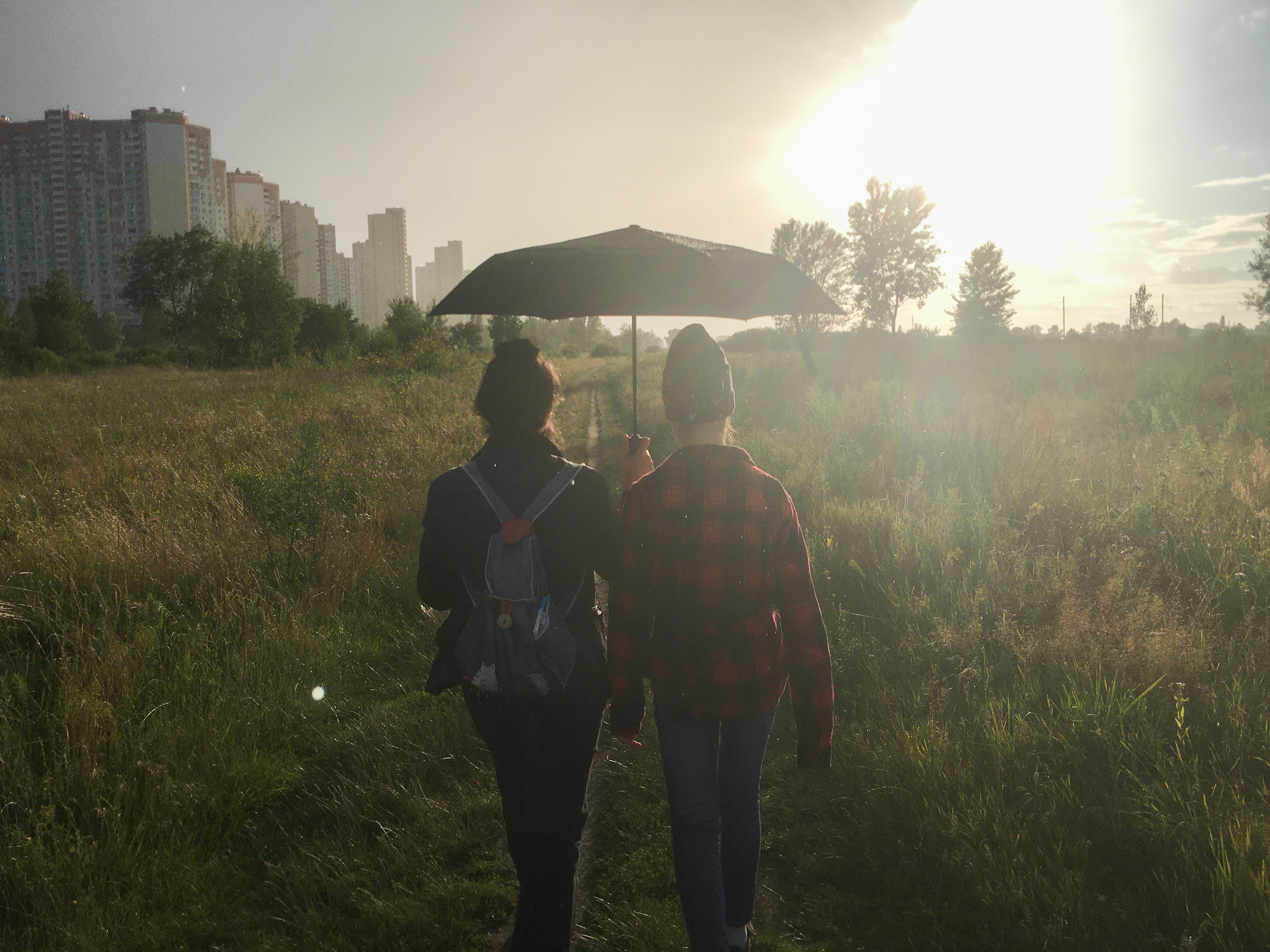 Two people walking in a meadow near their home in kyiv.