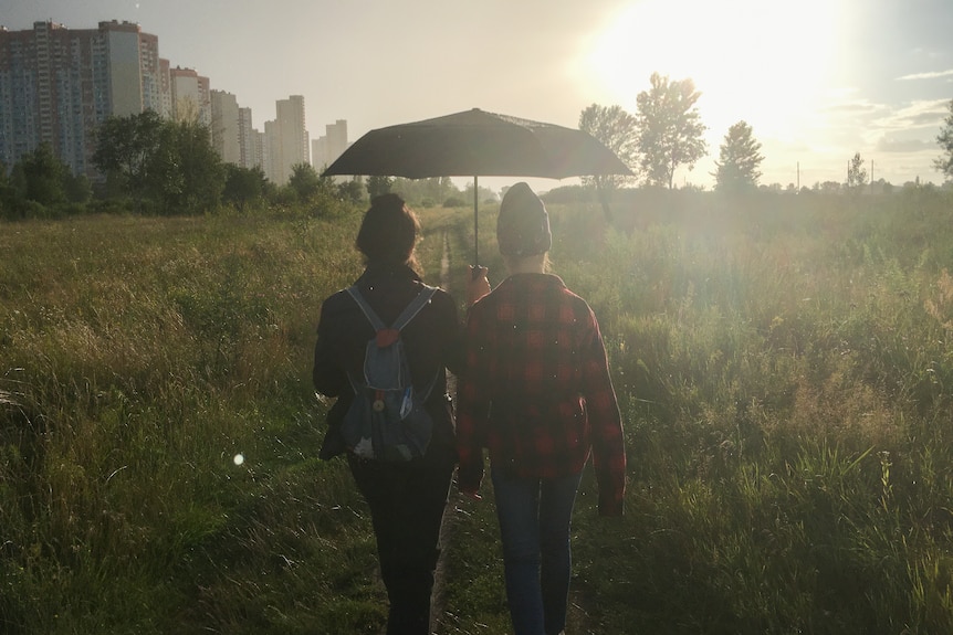 Two people walking in a meadow near their home in Kiev.